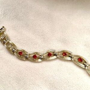 FROM 1950s UNIQUE GOLD-COLORED BRACELET intricate links and red-orange stones.